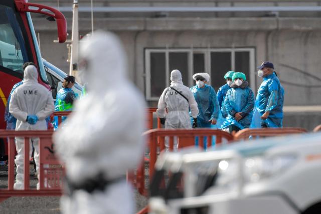 Passengers wearing a blue protective suits board a military bus after being evacuated from the Dutch flagged hantavirus-stricken cruise ship MV Hondius at the industrial port of Granadilla de Abona on the island of Tenerife in Spain's Canary Islands on May 10, 2026. Repatriation flights for the nearly 150 passengers onboard the ship hit by a deadly hantavirus outbreak began as passengers were transferred to shore on smaller vessels then by bus to the airport to be flown home after weeks at sea. (Photo by JORGE GUERRERO / AFP)