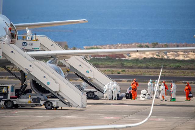 Spanish evacuees wearing white hazmat protective suits board a Spanish air force Airbus A310 plane at the Tenerife Sur-Reina Sofia airport after being evacuated from the Dutch flagged hantavirus-stricken cruise ship MV Hondius  on the island of Tenerife in Spain's Canary Islands on May 10, 2026. Repatriation flights for the nearly 150 passengers onboard the ship hit by a deadly hantavirus outbreak began as passengers were transferred to shore on smaller vessels then by bus to the airport to be flown home after weeks at sea. (Photo by Antonio Sempere / AFP)