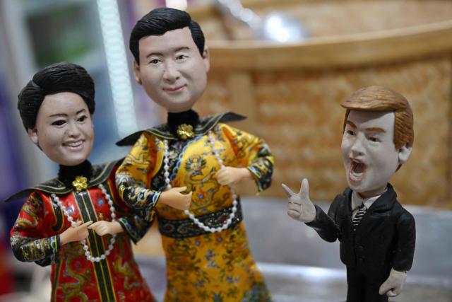 Plastic figures depicting China's President Xi Jinping (C) dressed as a Qing Dynasty emperor with his wife Peng Liyuan (L), and US President Donald Trump (R) are displayed for sale in a store in Beijing on May 10, 2026. Trump is due to visit China on May 14-15 where he is expected to meet with China's President Xi after delaying an earlier summit due to the Middle East war. (Photo by Pedro PARDO / AFP)