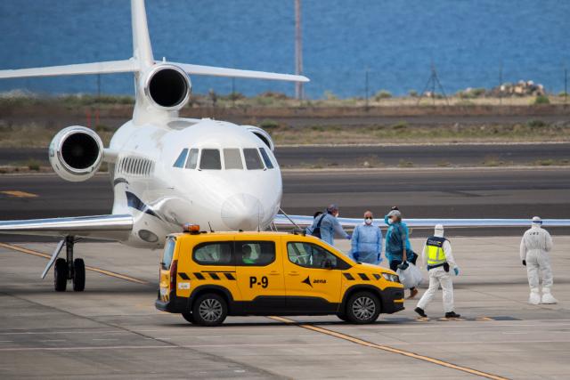 A passenger wearing a blue protective suit boards a French govenment plane at the Tenerife Sur-Reina Sofia airport after being evacuated from the Dutch flagged hantavirus-stricken cruise ship MV Hondius on the island of Tenerife in Spain's Canary Islands on May 10, 2026. Repatriation flights for the nearly 150 passengers onboard the ship hit by a deadly hantavirus outbreak got underway as passengers and some crew members were transferred to shore on smaller vessels then by bus to the airport and then flown home after weeks at sea. (Photo by Antonio Sempere / AFP)