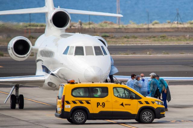 Passengers wearing blue protective suits board a French govenment plane at the Tenerife Sur-Reina Sofia airport after being evacuated from the Dutch flagged hantavirus-stricken cruise ship MV Hondius on the island of Tenerife in Spain's Canary Islands on May 10, 2026. Repatriation flights for the nearly 150 passengers onboard the ship hit by a deadly hantavirus outbreak got underway as passengers and some crew members were transferred to shore on smaller vessels then by bus to the airport and then flown home after weeks at sea. (Photo by Antonio Sempere / AFP)