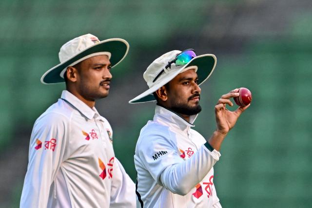 Bangladesh's Mehidy Hasan Miraz (R) acknowledges the crowd after taking a five-wicket haul during the third day of the first Test cricket match between Bangladesh and Pakistan at the Sher-e-Bangla National Stadium in Mirpur on May 10, 2026. (Photo by Munir UZ ZAMAN / AFP)