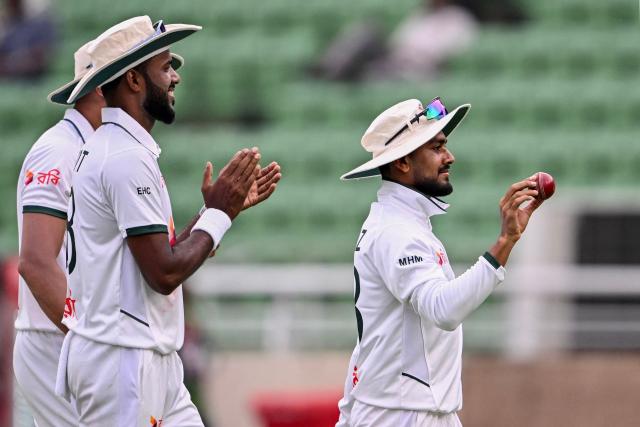Bangladesh's Mehidy Hasan Miraz (R) acknowledges the crowd after taking a five-wicket haul during the third day of the first Test cricket match between Bangladesh and Pakistan at the Sher-e-Bangla National Stadium in Mirpur on May 10, 2026. (Photo by Munir UZ ZAMAN / AFP)