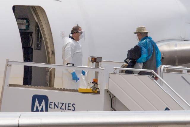 A Canadian passenger boards a plane at the Tenerife Sur-Reina Sofia airport after being evacuated from the Dutch flagged hantavirus-stricken cruise ship MV Hondius on the island of Tenerife in Spain's Canary Islands on May 10, 2026. Repatriation flights for the nearly 150 passengers onboard the ship hit by a deadly hantavirus outbreak got underway as passengers and some crew members were transferred to shore on smaller vessels then by bus to the airport and then flown home after weeks at sea. (Photo by Antonio Sempere / AFP)