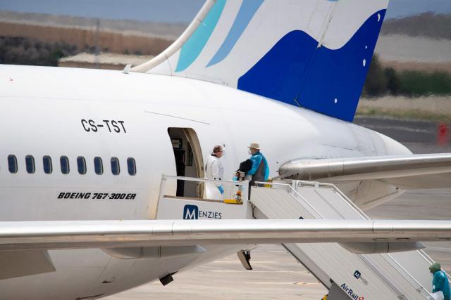 Canadian passengers board a plane at the Tenerife Sur-Reina Sofia airport after being evacuated from the Dutch flagged hantavirus-stricken cruise ship MV Hondius on the island of Tenerife in Spain's Canary Islands on May 10, 2026. Repatriation flights for the nearly 150 passengers onboard the ship hit by a deadly hantavirus outbreak got underway as passengers and some crew members were transferred to shore on smaller vessels then by bus to the airport and then flown home after weeks at sea. (Photo by Antonio Sempere / AFP)