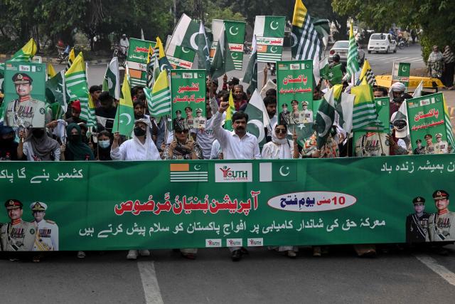 Youth Forum for Kashmir (YFK) activists hold a banner reading "Bunyan-um-Marsoos" as they march during a rally to mark one year since the India-Pakistan conflict, in Lahore on May 10, 2026. (Photo by Arif ALI / AFP)
