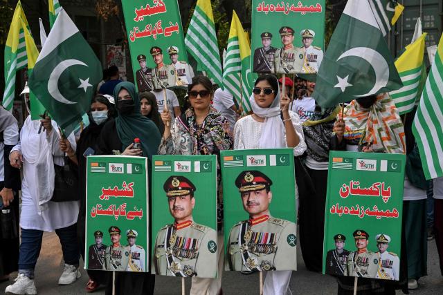 Youth Forum for Kashmir (YFK) activists hold a banner reading "Bunyan-um-Marsoos" as they march during a rally to mark one year since the India-Pakistan conflict, in Lahore on May 10, 2026. (Photo by Arif ALI / AFP)