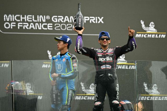 Aprilia Racing's Spanish rider Jorge Martin (R) celebrates on the podium next to third placed Trackhouse Racing MotoGP Team's Japanese rider Ai Ogura (L) after winning the Moto GP Grand Prix of France at Le Mans, northwestern France, on May 10, 2026. (Photo by Loic VENANCE / AFP)
