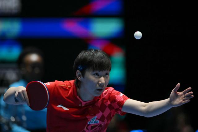China's Wang Manyu serves against Japan's Hina Hayata during their Women's Teams final match at the ITTF World Table Tennis Championships in Wembley Arena, west London on May 10, 2026. (Photo by Glyn KIRK / AFP)