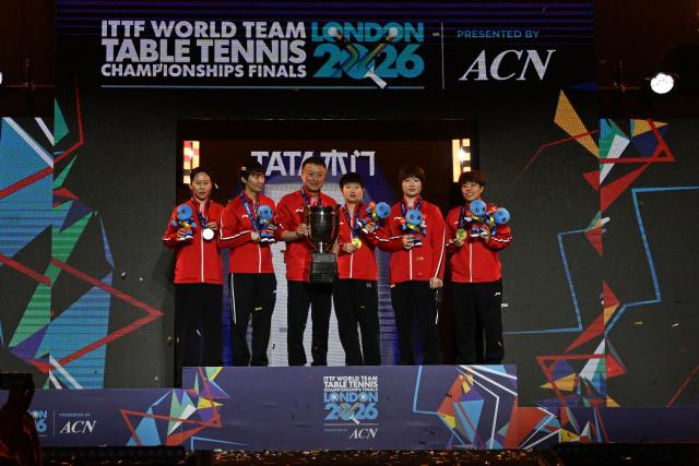Team China celebrate with their trophies at the award ceremony after beating Japan in the Women's Teams final at the ITTF World Table Tennis Championships in Wembley Arena, west London on May 10, 2026. China won the final 3-2. (Photo by Glyn KIRK / AFP)
