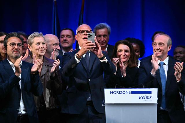 TOPSHOT - French right-wing party Horizons founder and president, mayor of Le Havre and candidate for the 2027 French presidential election Edouard Philippe (C) takes a photograph as he stands on stage with (From L) Reims' mayor Arnaud Robinet, France’s junior Minister in charge of artificial intelligence Anne Le Henanff, former journalist turned politician Patrick de Carolis, Pays de la Loire region president Christelle Morancais and MP Laurent Marcangeli, at the end of a party’s senior officials rally in Reims on May 10, 2026. (Photo by Martin BUREAU / AFP)
