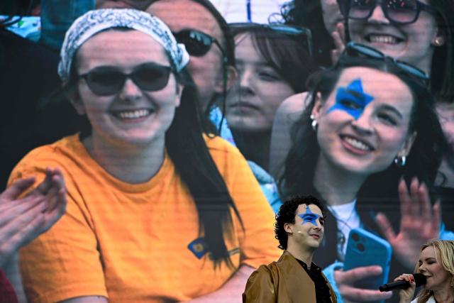 Austrian singer Benjamin Gedeon, aka Cosmo and representing Austria with the song 'Tanzschein', greets supporters on stage ahead of the opening ceremony of the Eurovision Song Contest 2026 at the City Hall Square in Vienna, Austria on May 10, 2026. The event is the official starting point of Eurovision week in Vienna. The city will host the two semi-finals on May 12 and May 14 and the final on May 16, 2026. (Photo by Tobias SCHWARZ / AFP)