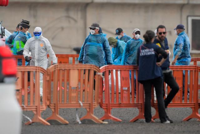 Passengers from Britain that were evacuated off the Dutch flagged hantavirus-stricken cruise ship MV Hondius are led to military buses at the industrial port of Granadilla de Abona on the island of Tenerife in Spain's Canary Islands on May 10, 2026. Repatriation flights for the nearly 150 passengers onboard the ship hit by a deadly hantavirus outbreak began as passengers were transferred to shore on smaller vessels then by bus to the airport to be flown home after weeks at sea. (Photo by JORGE GUERRERO / AFP)