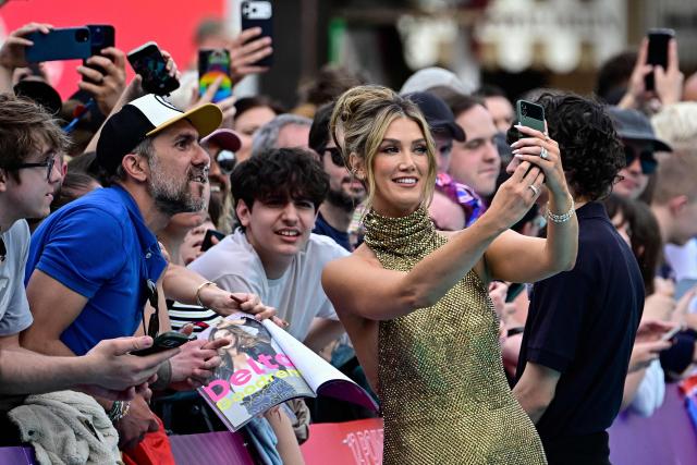 Australian singer Delta Goodrem, representing Australia with the song 'Eclipse', pose for selfies with fans on the turquoise carpet for the opening ceremony of the Eurovision Song Contest 2026 at the City Hall Square in Vienna, Austria on May 10, 2026. The event is the official starting point of Eurovision week in Vienna. The city will host the two semi-finals on May 12 and May 14 and the final on May 16, 2026. (Photo by Tobias SCHWARZ / AFP)