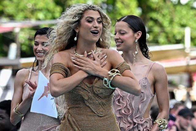Cypriot singer Antigoni Buxton, aka Antigoni and representing Cyprus with the song 'Jalla', pose for selfies with fans on the turquoise carpet for the opening ceremony of the Eurovision Song Contest 2026 at the City Hall Square in Vienna, Austria on May 10, 2026. The event is the official starting point of Eurovision week in Vienna. The city will host the two semi-finals on May 12 and May 14 and the final on May 16, 2026. (Photo by Tobias SCHWARZ / AFP)
