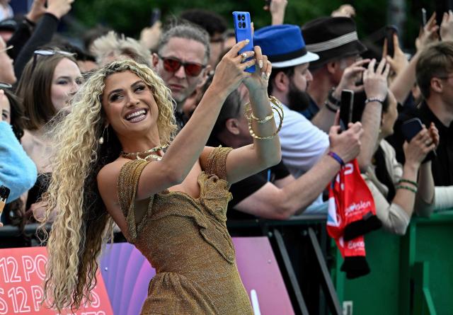 Cypriot singer Antigoni Buxton, aka Antigoni and representing Cyprus with the song 'Jalla', pose for selfies with fans on the turquoise carpet for the opening ceremony of the Eurovision Song Contest 2026 at the City Hall Square in Vienna, Austria on May 10, 2026. The event is the official starting point of Eurovision week in Vienna. The city will host the two semi-finals on May 12 and May 14 and the final on May 16, 2026. (Photo by Tobias SCHWARZ / AFP)