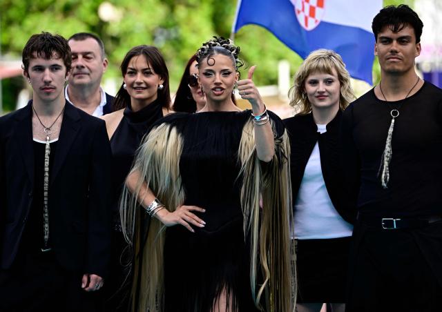Darina Nikolaeva Yotova (C), aka Dara and representing Bulgaria with the song 'Bangaranga', poses for photographers on the turquoise carpet for the opening ceremony of the Eurovision Song Contest 2026 at the City Hall Square in Vienna, Austria on May 10, 2026. The event is the official starting point of Eurovision week in Vienna. The city will host the two semi-finals on May 12 and May 14 and the final on May 16, 2026. (Photo by Tobias SCHWARZ / AFP)