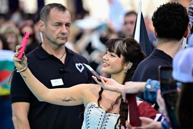 Belgian singer Alice Van Eesbeeck, aka Essyla and representing Belgium with the song 'Dancing on the Ice', poses for selfies on the turquoise carpet for the opening ceremony of the Eurovision Song Contest 2026 at the City Hall Square in Vienna, Austria on May 10, 2026. The event is the official starting point of Eurovision week in Vienna. The city will host the two semi-finals on May 12 and May 14 and the final on May 16, 2026. (Photo by Tobias SCHWARZ / AFP)