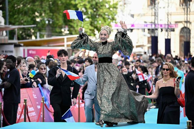 Monroe Vata Rigby, aka Monroe and representing France with the song 'Regarde !', pose for photographers on the turquoise carpet for the opening ceremony of the Eurovision Song Contest 2026 at the City Hall Square in Vienna, Austria on May 10, 2026. The event is the official starting point of Eurovision week in Vienna. The city will host the two semi-finals on May 12 and May 14 and the final on May 16, 2026. (Photo by Tobias SCHWARZ / AFP)