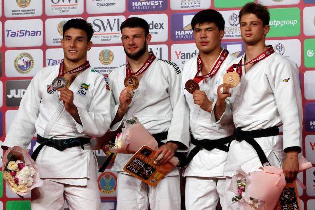 Silver medallist Brazil's Guilherme Schimidt, gold medallist Serbia's Boris Rutovic and bronze medallists Kazakhstan's Aidar Arapov and Moldova's Mihail Latisev celebrate on the podium for the men's under 90 kg event at the Astana Grand Slam judo tournament in Astana on May 10, 2026. (Photo by STANISLAV FILIPPOV / AFP)