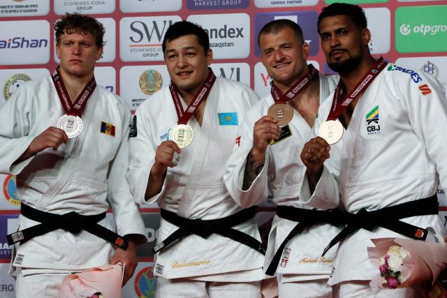 Silver medallist Moldova's Vadim Ghimbovschi, gold medallist Kazakhstan's Marat Baikamurov and bronze medallists Netherlands' Michael Korrel and Brazil's Leonardo Goncalves celebrate on the podium for the men's under 100 kg event at the Astana Grand Slam judo tournament in Astana on May 10, 2026. (Photo by STANISLAV FILIPPOV / AFP)