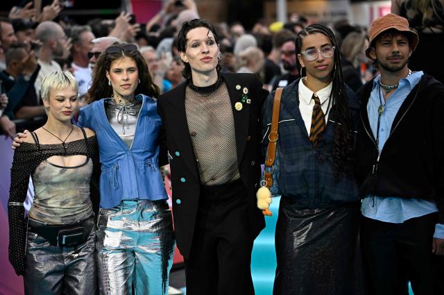 Danish singer Soeren Torpegaard Lund (C), representing Denmark with the song 'For Vi Gar Hjem', poses for photographers on the turquoise carpet for the opening ceremony of the Eurovision Song Contest 2026 at the City Hall Square in Vienna, Austria on May 10, 2026. The event is the official starting point of Eurovision week in Vienna. The city will host the two semi-finals on May 12 and May 14 and the final on May 16, 2026. (Photo by Tobias SCHWARZ / AFP)
