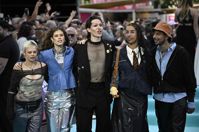 Danish singer Soeren Torpegaard Lund (C), representing Denmark with the song 'For Vi Gar Hjem', poses for photographers on the turquoise carpet for the opening ceremony of the Eurovision Song Contest 2026 at the City Hall Square in Vienna, Austria on May 10, 2026. The event is the official starting point of Eurovision week in Vienna. The city will host the two semi-finals on May 12 and May 14 and the final on May 16, 2026. (Photo by Tobias SCHWARZ / AFP)
