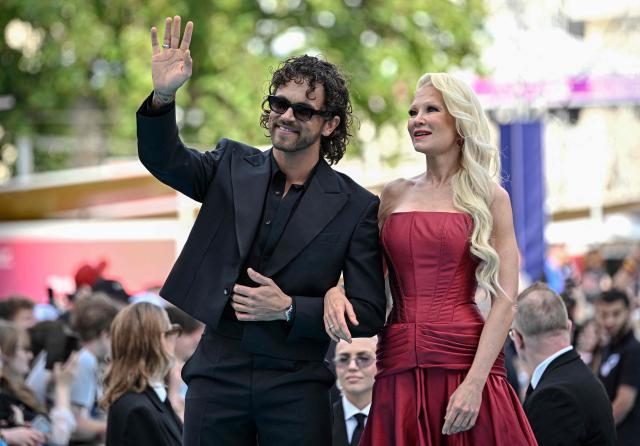 Finnish singers Linda Lampenius (R) and Pete Parkkonen, representing Finland with the song 'Liekinheitin', pose for photographers on the turquoise carpet for the opening ceremony of the Eurovision Song Contest 2026 at the City Hall Square in Vienna, Austria on May 10, 2026. The event is the official starting point of Eurovision week in Vienna. The city will host the two semi-finals on May 12 and May 14 and the final on May 16, 2026. (Photo by Tobias SCHWARZ / AFP)