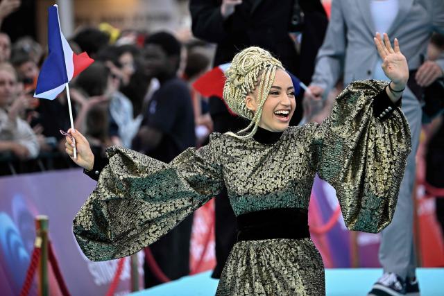 Monroe Vata Rigby, aka Monroe and representing France with the song 'Regarde !', pose for photographers on the turquoise carpet for the opening ceremony of the Eurovision Song Contest 2026 at the City Hall Square in Vienna, Austria on May 10, 2026. The event is the official starting point of Eurovision week in Vienna. The city will host the two semi-finals on May 12 and May 14 and the final on May 16, 2026. (Photo by Tobias SCHWARZ / AFP)