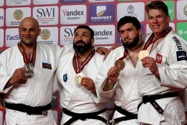 Silver medallist Azerbaijan's Ushangi Kokauri, gold medallist Russia's Inal Tasoev and bronze medallists United Arab Emirates' Magomedomar Magomedomarov and Poland's Jakub Sordyl celebrate on the podium for the men's over 100 kg event at the Astana Grand Slam judo tournament in Astana on May 10, 2026. (Photo by STANISLAV FILIPPOV / AFP)