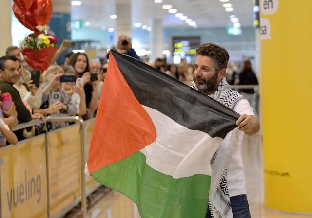 Spanish activist from a Gaza-bound aid flotilla Saif Abu Keshek waves a Palestinian flag he arrives after being released by Israeli authorities at Barcelona airport, on May 10, 2026. Israeli forces intercepted the flotilla in international waters off Greece last week, expelling the activists to Europe but arresting Abu Keshek and another activist from Gaza-bound aid flotilla. (Photo by MANAURE QUINTERO / AFP)