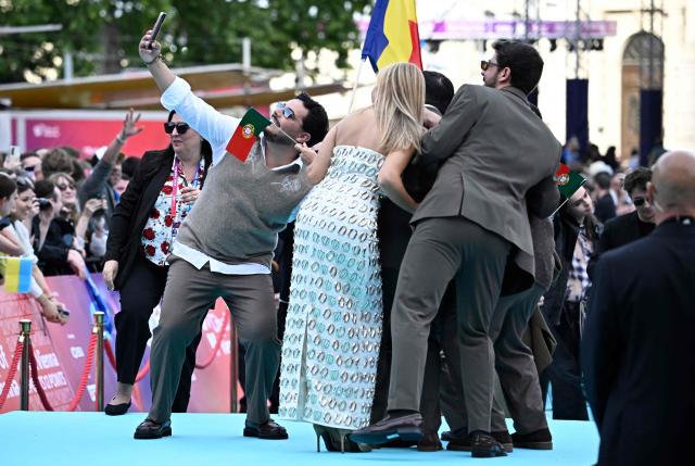 Portuguese singers Miguel Costa, Duarte Farias, Francisco Raposo, Luis Aleixo and Francisco Pestana of band Bandidos do Cante and representing Portugal with the song 'Rosa', pose for photographers on the turquoise carpet for the opening ceremony of the Eurovision Song Contest 2026 at the City Hall Square in Vienna, Austria on May 10, 2026. The event is the official starting point of Eurovision week in Vienna. The city will host the two semi-finals on May 12 and May 14 and the final on May 16, 2026. (Photo by Tobias SCHWARZ / AFP)