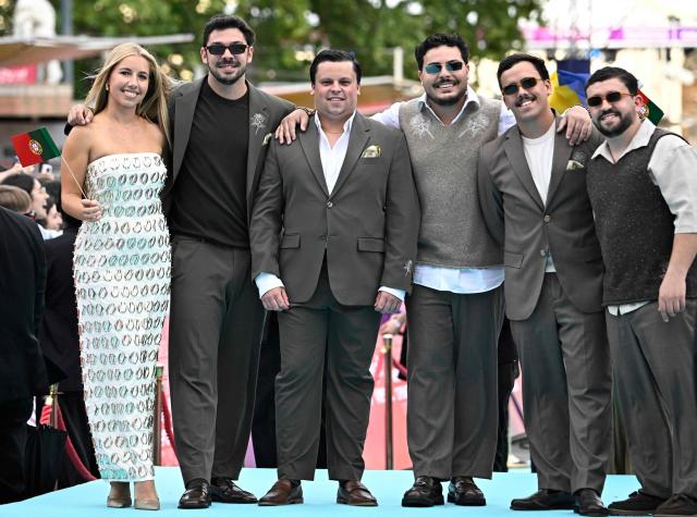 Portuguese singers Miguel Costa, Duarte Farias, Francisco Raposo, Luis Aleixo and Francisco Pestana of band Bandidos do Cante and representing Portugal with the song 'Rosa', pose for photographers on the turquoise carpet for the opening ceremony of the Eurovision Song Contest 2026 at the City Hall Square in Vienna, Austria on May 10, 2026. The event is the official starting point of Eurovision week in Vienna. The city will host the two semi-finals on May 12 and May 14 and the final on May 16, 2026. (Photo by Tobias SCHWARZ / AFP)
