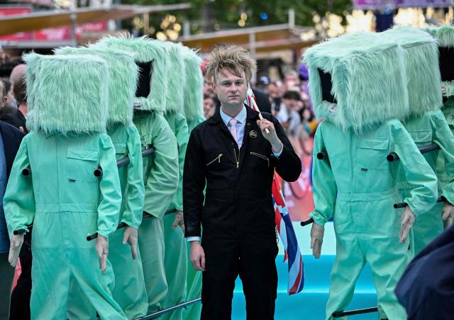 English musician Sam Battle, aka Look Mum No Computer and representing Great Britain with the song 'Eins, Zwei, Drei', pose for photographers on the turquoise carpet for the opening ceremony of the Eurovision Song Contest 2026 at the City Hall Square in Vienna, Austria on May 10, 2026. The event is the official starting point of Eurovision week in Vienna. The city will host the two semi-finals on May 12 and May 14 and the final on May 16, 2026. (Photo by Tobias SCHWARZ / AFP)