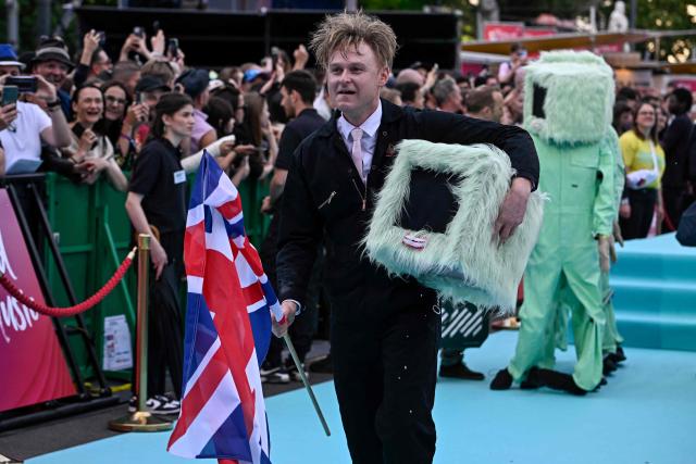 English musician Sam Battle, aka Look Mum No Computer and representing Great Britain with the song 'Eins, Zwei, Drei', pose for photographers on the turquoise carpet for the opening ceremony of the Eurovision Song Contest 2026 at the City Hall Square in Vienna, Austria on May 10, 2026. The event is the official starting point of Eurovision week in Vienna. The city will host the two semi-finals on May 12 and May 14 and the final on May 16, 2026. (Photo by Tobias SCHWARZ / AFP)