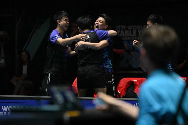 China's Lin Shidong celebrates with teammates after beating Japan's Shunsuke Togami to secure China's victory in the Men's Teams final match at the ITTF World Table Tennis Championships in Wembley Arena, west London on May 10, 2026. China beat Japan 3-0. (Photo by Glyn KIRK / AFP)