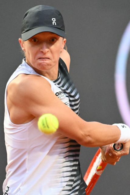 Poland's Iga Swiatek plays a backhand return to Italy's Elisabetta Cocciaretto during their women's singles match at the WTA Rome Open tennis tournament at Foro Italico in Rome on May 10, 2026. (Photo by Alberto PIZZOLI / AFP)