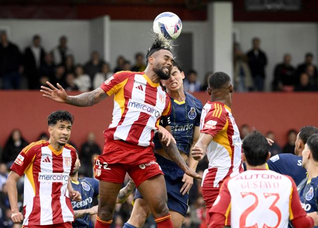 AVS' Colombian defender #42 Cristian Devenish and FC Porto's Croatian defender #21 Dominik Prpic vie for a header during the Portuguese League football match between AVS Futebol SAD and FC Porto at at CD Aves stadium in Vila das Aves on May 10, 2026. (Photo by Miguel RIOPA / AFP)