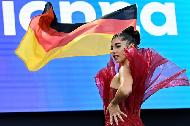 German singer Sarah Engels, representing Germany with the song 'Fire', holds the German flag at the opening ceremony of the Eurovision Song Contest 2026 at the City Hall Square in Vienna, Austria on May 10, 2026. The event is the official starting point of Eurovision week in Vienna. The city will host the two semi-finals on May 12 and May 14 and the final on May 16, 2026. (Photo by Tobias SCHWARZ / AFP) / ALTERNATIVE CROP
