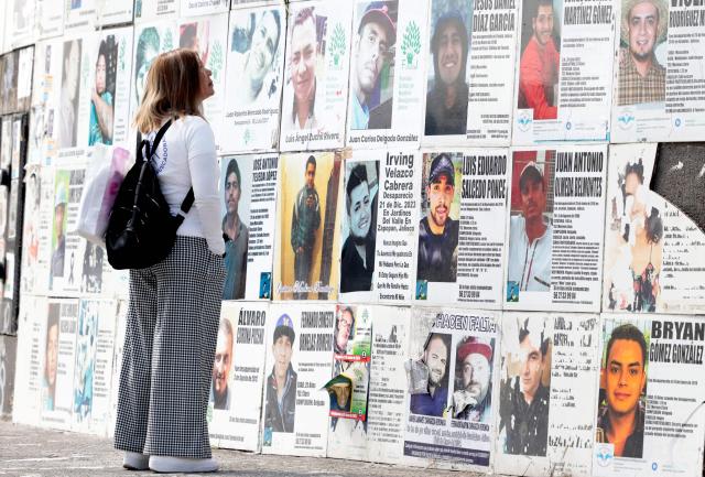 A mother searching for her missing son looks at a poster bearing his image at the Glorieta de los Desaparecidos (Roundabout of the Disappeared) during a protest on Mother's Day, in Guadalajara, Jalisco state, Mexico, on May 10, 2026. (Photo by ULISES RUIZ / AFP)