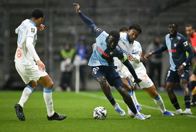 Le Havre's Senegalese defender #93 Arouna Sangante (C) fights for the ball with Marseille's Moroccan defender #21 Nayef Aguerd (C/R) during the French L1 football match between Le Havre AC and Olympique de Marseille (OM) at the Stade Oceane in Le Havre, north-western France on May 10, 2026. (Photo by LOU BENOIST / AFP)