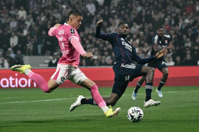Toulouse's Argentine forward #11 Santiago Hidalgo (L) runs with the ball as Lyon's Angolan defender #22 Clinton Mata (R) tackles during the French L1 football match between Toulouse FC and Olympique Lyonnais (OL) at the TFC Stadium in Toulouse, south-western France on May 10, 2026. (Photo by Ed JONES / AFP)