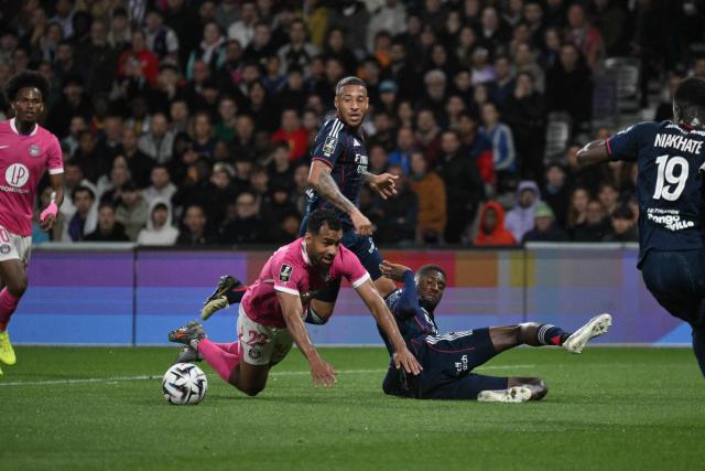 Toulouse's Venezuelan midfielder #23 Cristian Casseres Jr. (C) falls after a tackle from Lyon's Angolan defender #22 Clinton Mata (top C) during the French L1 football match between Toulouse FC and Olympique Lyonnais (OL) at the TFC Stadium in Toulouse, southwestern France, on May 10, 2026. (Photo by Ed JONES / AFP)