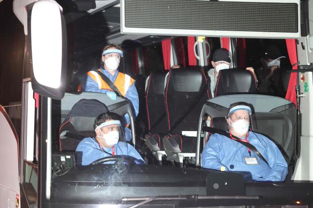 British Nationals, repatriated after a prolonged stay on a cruise ship hit by a deadly hantavirus outbreak, arrive by coach at Arrowe Park Hospital in Wirral, north west England, on May 10, 2026, where they are expected to stay for up to 72 hours. Repatriation flights for passengers aboard the cruise ship MV Hondius, hit by a deadly hantavirus outbreak have taken off for destinations across the world. British passengers returning to the UK, will have to isolate for 45 days, and will be closely monitored and tested. (Photo by Toby Shepheard / AFP)