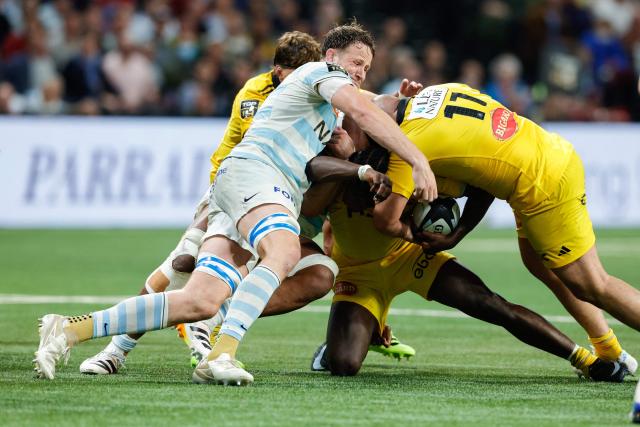 La Rochelle's French flanker Andy Timo (C) fights for the ball with Racing 92' English lock Jonathan Hill (L) during the French Top14 rugby union match between Racing 92 and Stade Rochelais (La Rochelle) at the Paris La Defense Arena in Nanterre, on the outskirts of Paris on May 10, 2026. (Photo by GEOFFROY VAN DER HASSELT / AFP)