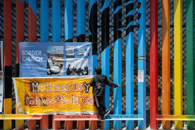 A child plays climbing the Mexico-US border wall during Mother's Day celebrations in Playas de Tijuana, Baja California state, Mexico on May 10, 2026. (Photo by Guillermo Arias / AFP)