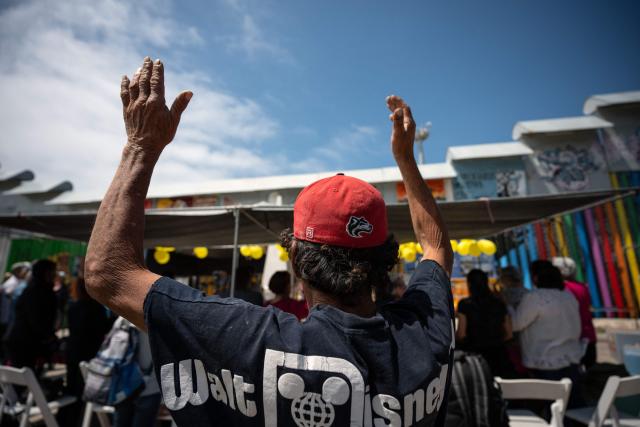 A person gestures during a mass service attended by migrant mothers during Mother's Day at the Mexico-US border in Playas de Tijuana, Baja California state, Mexico on May 10, 2026. (Photo by Guillermo Arias / AFP)