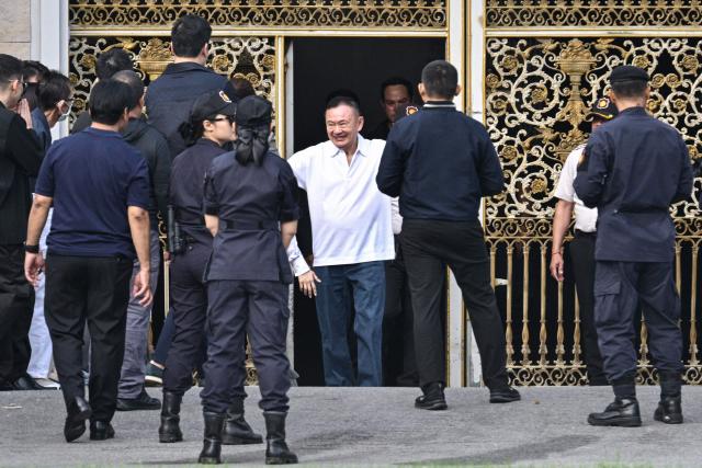 Thailand's former prime minister Thaksin Shinawatra (C) is greeted by his family members and relatives upon his release at Klong Prem Central Prison in Bangkok on May 11, 2026. Thailand's former prime minister Thaksin Shinawatra was set to be released early from prison on May 11, raising the prospect of a return to the spotlight for the political heavyweight. (Photo by ANTHONY WALLACE / AFP)