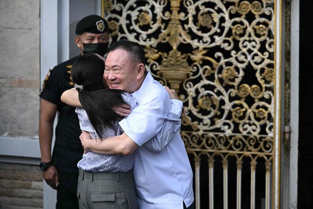Thailand's former prime minister Thaksin Shinawatra (R) hugs his daughter Paetongtarn Shinawatra upon his release at Klong Prem Central Prison in Bangkok on May 11, 2026. Thailand's former prime minister Thaksin Shinawatra was set to be released early from prison on May 11, raising the prospect of a return to the spotlight for the political heavyweight. (Photo by Lillian SUWANRUMPHA / AFP)