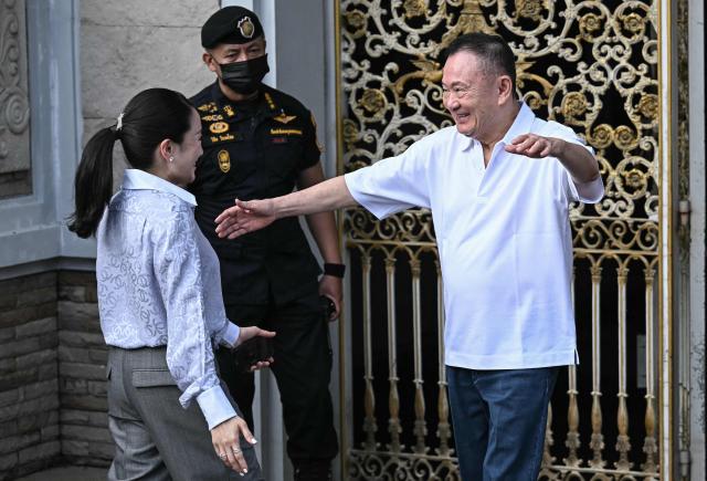 Thailand's former prime minister Thaksin Shinawatra (R) hugs his daughter Paetongtarn Shinawatra upon his release at Klong Prem Central Prison in Bangkok on May 11, 2026. Thailand's former prime minister Thaksin Shinawatra was set to be released early from prison on May 11, raising the prospect of a return to the spotlight for the political heavyweight. (Photo by Lillian SUWANRUMPHA / AFP)
